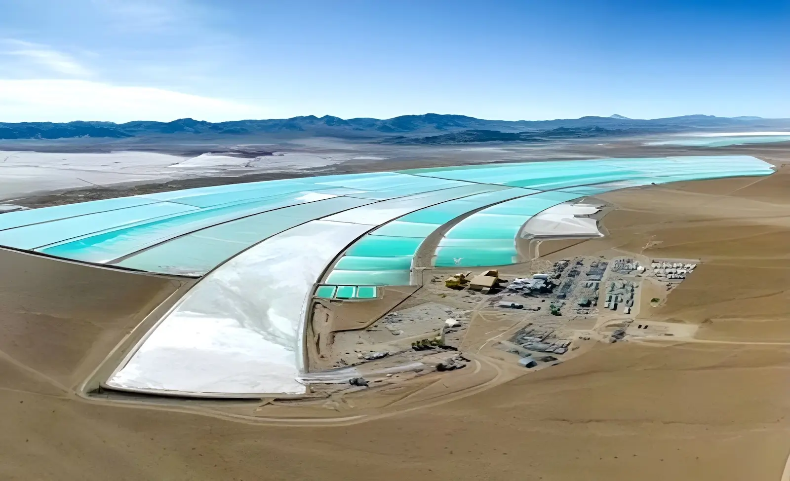 Aerial view of evaporation ponds at a lithium brine extraction site in Argentina, showcasing turquoise ponds and industrial infrastructure in a remote, arid desert landscape.