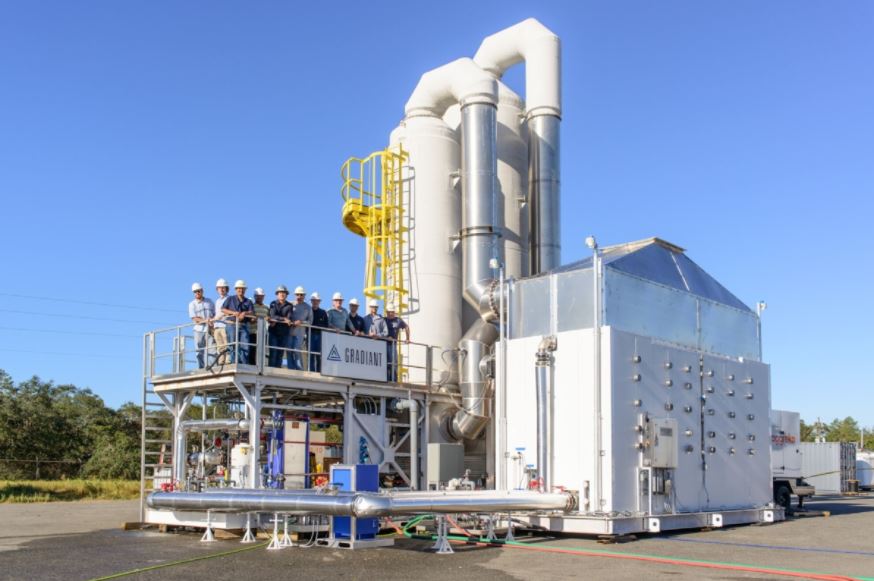 Gradiant engineers standing on a water treatment platform beside vertical treatment units, showcasing their installation used for industrial wastewater and water reuse projects in the Asia Pacific region.