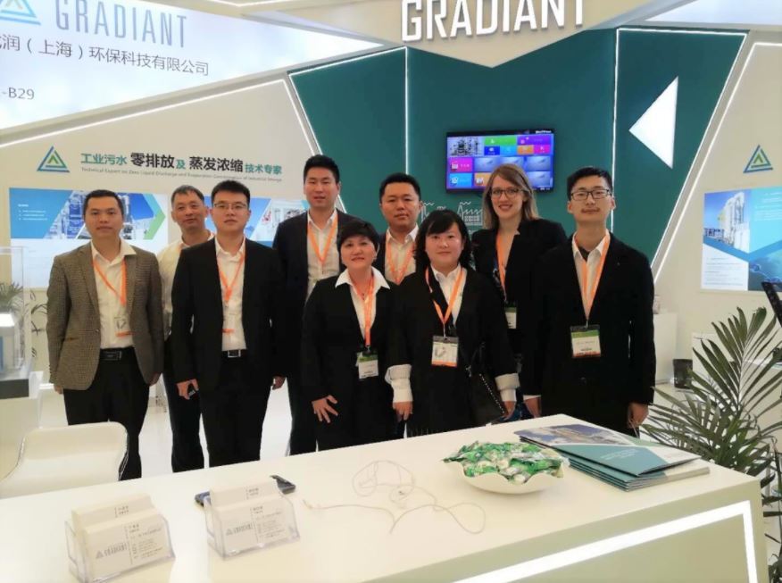 Gradiant China’s team at IE Expo China 2019 standing in front of their exhibition booth, showcasing industrial water treatment technologies to potential clients and partners.